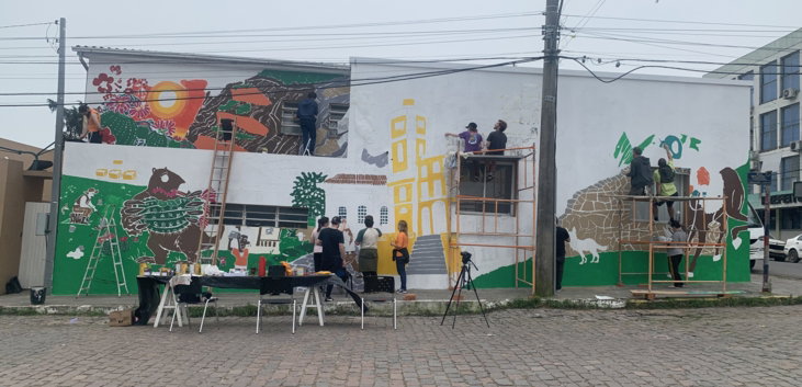 Alunos de desenho industrial da UFSM pintam um mural na casa de cultura